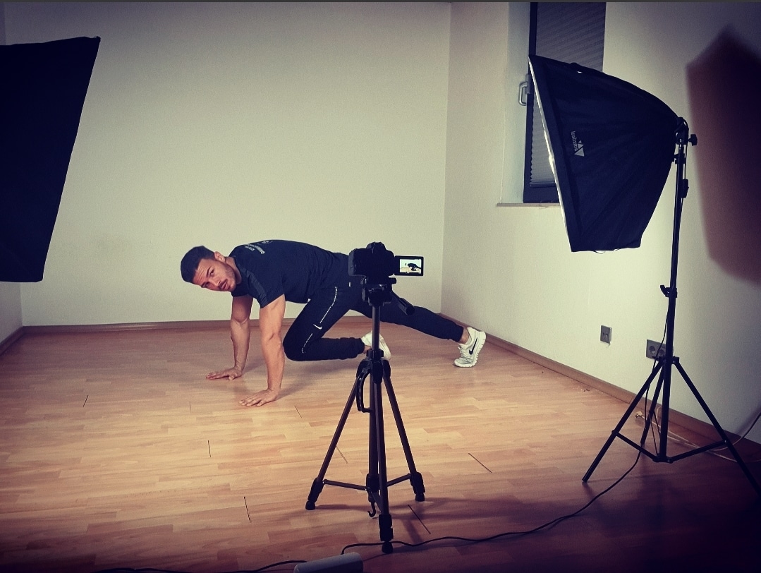 Personal Trainer Farris Elghadi beim Online Personal Training Online Personal Trainer Farris Elghadi trainiert in einem Zimmer vor einer Kamera mit Stativ